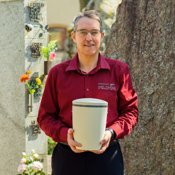 Michael Großhaupt von Kuhn Bestattungen mit Urne am Friedhof Asperg
