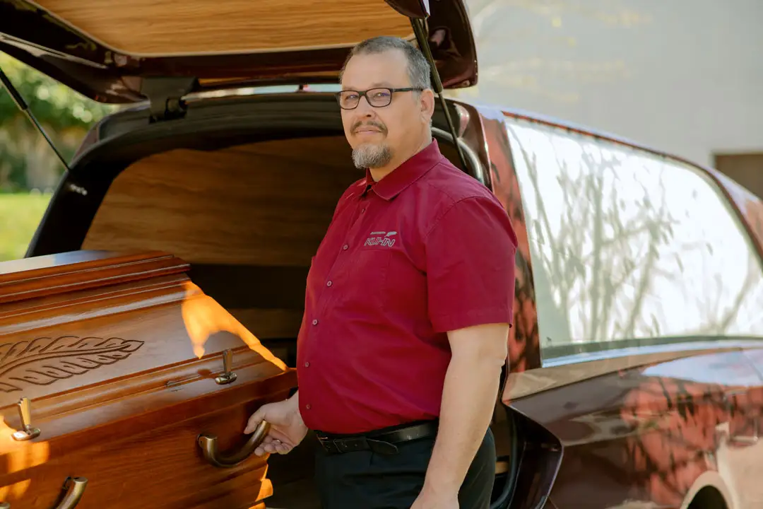 Würdevolle Überführungen mit Kuhn Bestattungen Fahrer von Kuhn Bestattungen beim Sargtransport