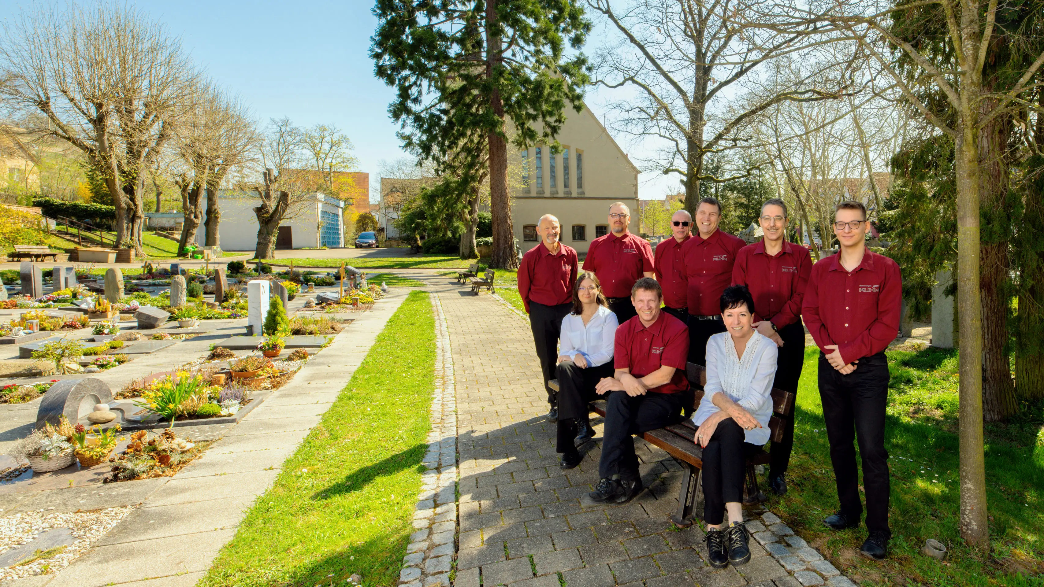 Verlässliches Team für Bestattungsvorsorge und Begleitung Das Team von Kuhn Bestattungen auf dem Friedhof in Asperg bei Sonnenschein