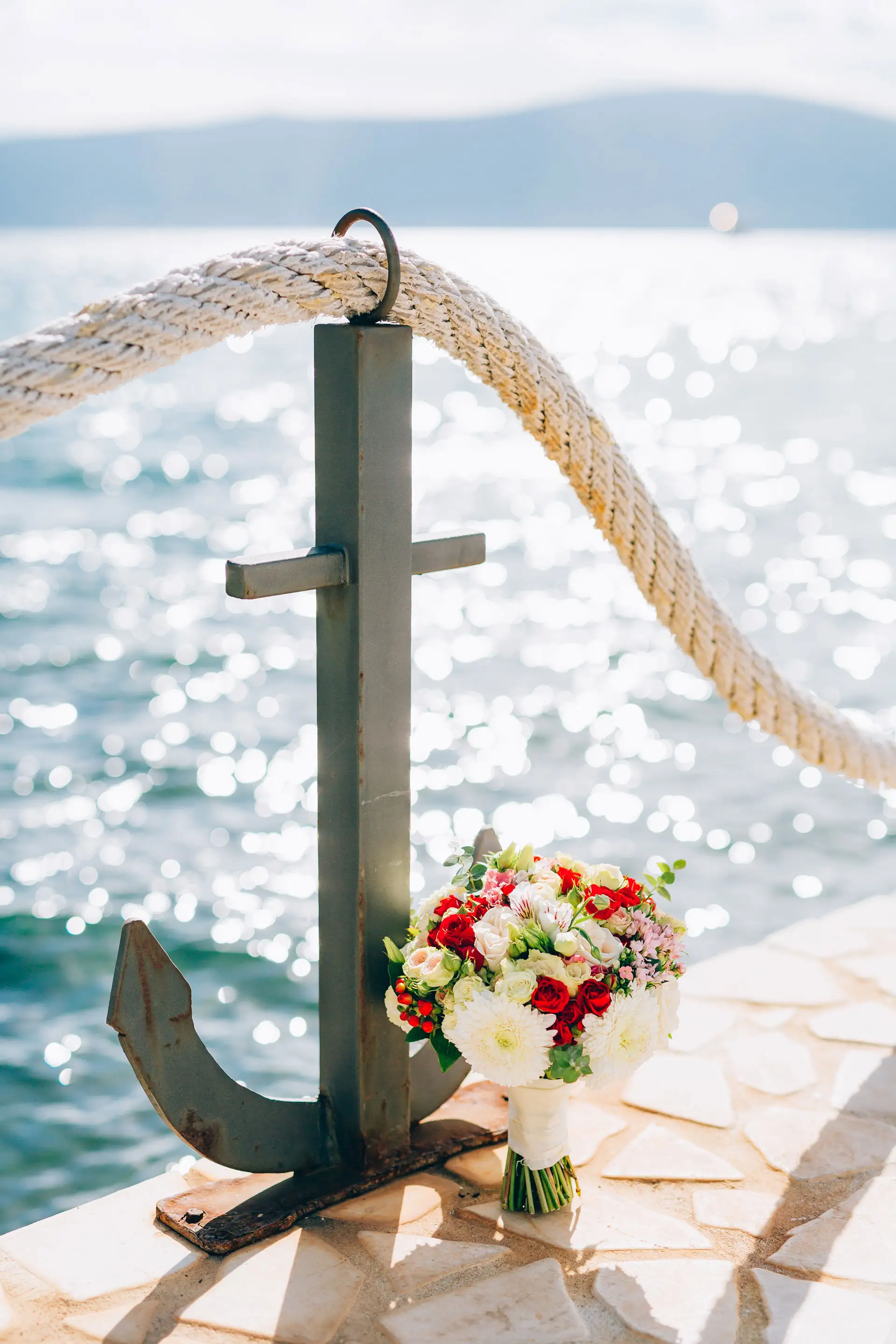 Seebestattung mit Blumenstrauß und Anker am Ufer, Kuhn Bestattungen Asperg Anker mit Blumenstrauß am Ufer für eine maritime Seebestattung, Kuhn Bestattungen Asperg