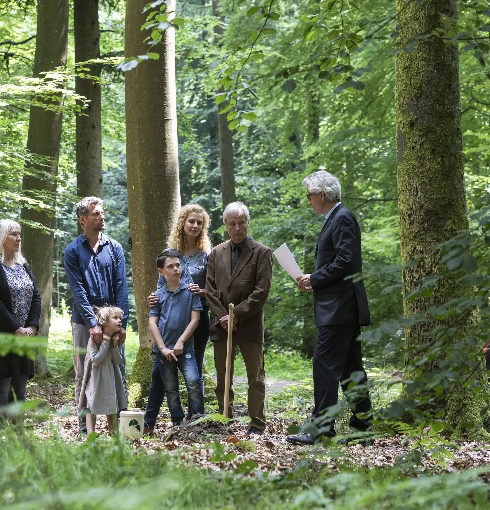 Trauerfeier im FriedWald: Familie mit Trauerredner bei einer Baumbestattung in einem Friedwald
